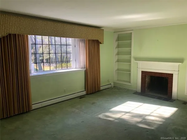 an empty room with a fireplace and windows