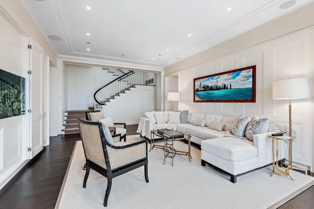 a living room with furniture a rug and a potted plant
