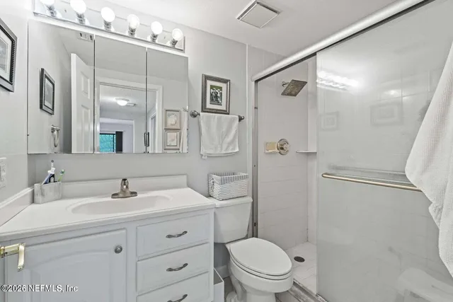 a bathroom with a sink a mirror a toilet and shower