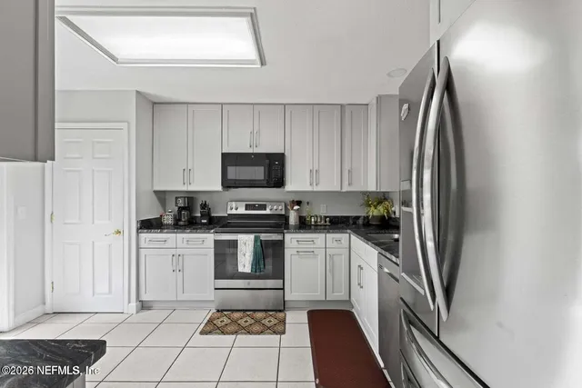 a kitchen with white cabinets and stainless steel appliances
