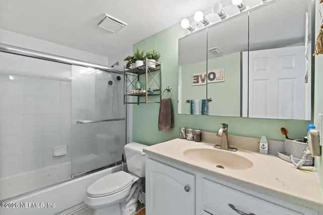 a bathroom with a sink toilet vanity tub and shower