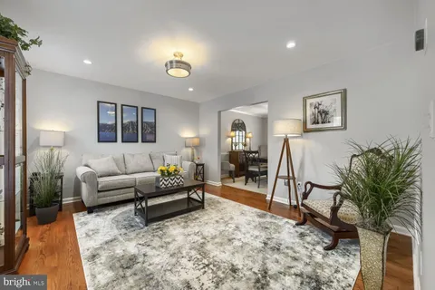 a living room with furniture a chandelier and a rug