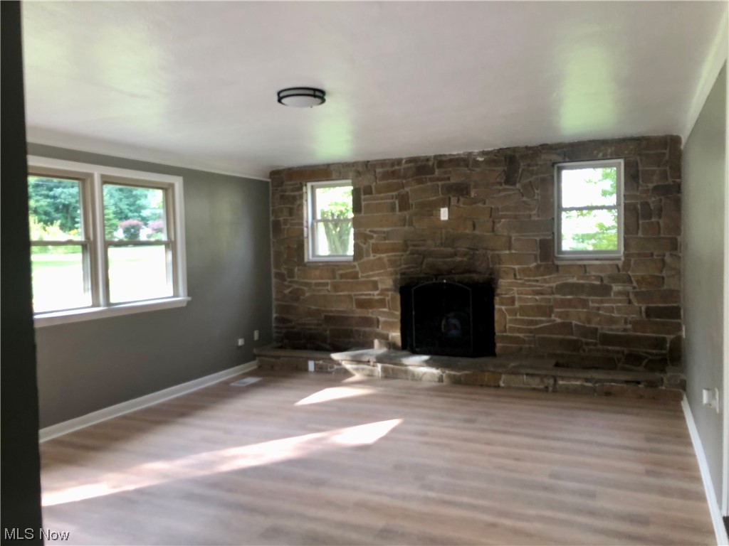 Living room with a wealth of natural light, light vinyl floors, and a fireplace