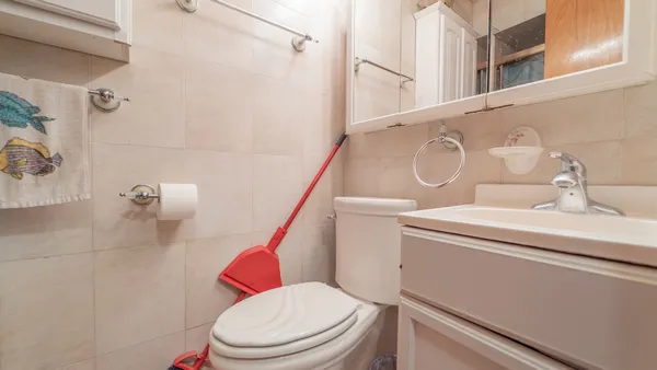 a white toilet sitting next to a bathroom sink