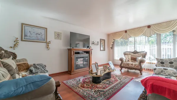 a living room with furniture a large window and a dining table
