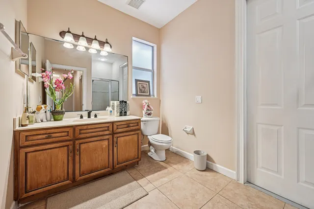 a spacious bathroom with a double vanity sink a mirror and a toilet