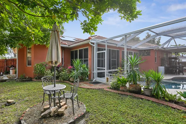 a view of a chair and table in backyard of the house