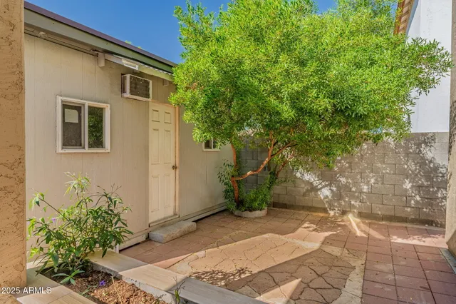 a view of a white house with a large tree and a yard