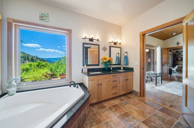 a large bathroom with a tub sink and mirror
