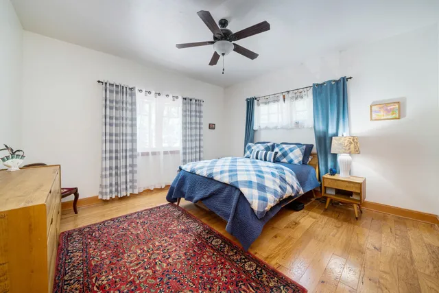 a bedroom with a bed and wooden floor