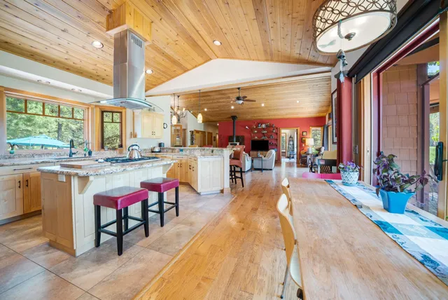 a living room with stainless steel appliances kitchen island granite countertop furniture and a large window