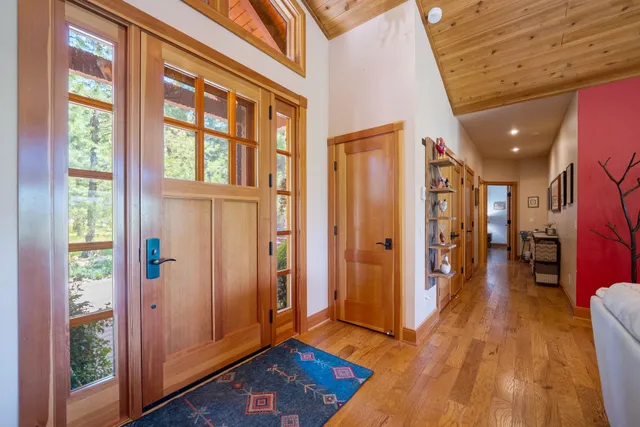 a view of a hallway with wooden floor and windows