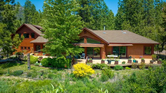 a view of a house with table and chairs under an umbrella