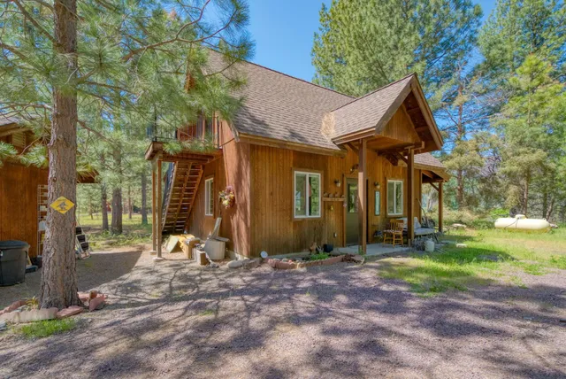 a view of a house with backyard and a tree