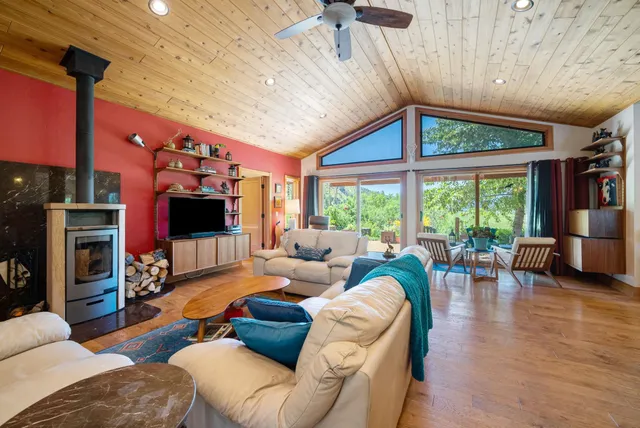 a living room with furniture a flat screen tv and a floor to ceiling window