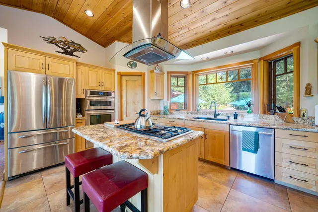 a kitchen with stainless steel appliances granite countertop a sink stove and refrigerator