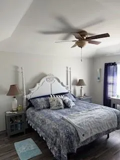 a bedroom with a bed a lamp on a table and a chandelier
