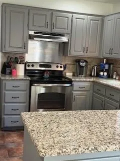 a kitchen with stainless steel appliances granite countertop a stove a sink and cabinets