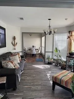 a living room with furniture and a chandelier