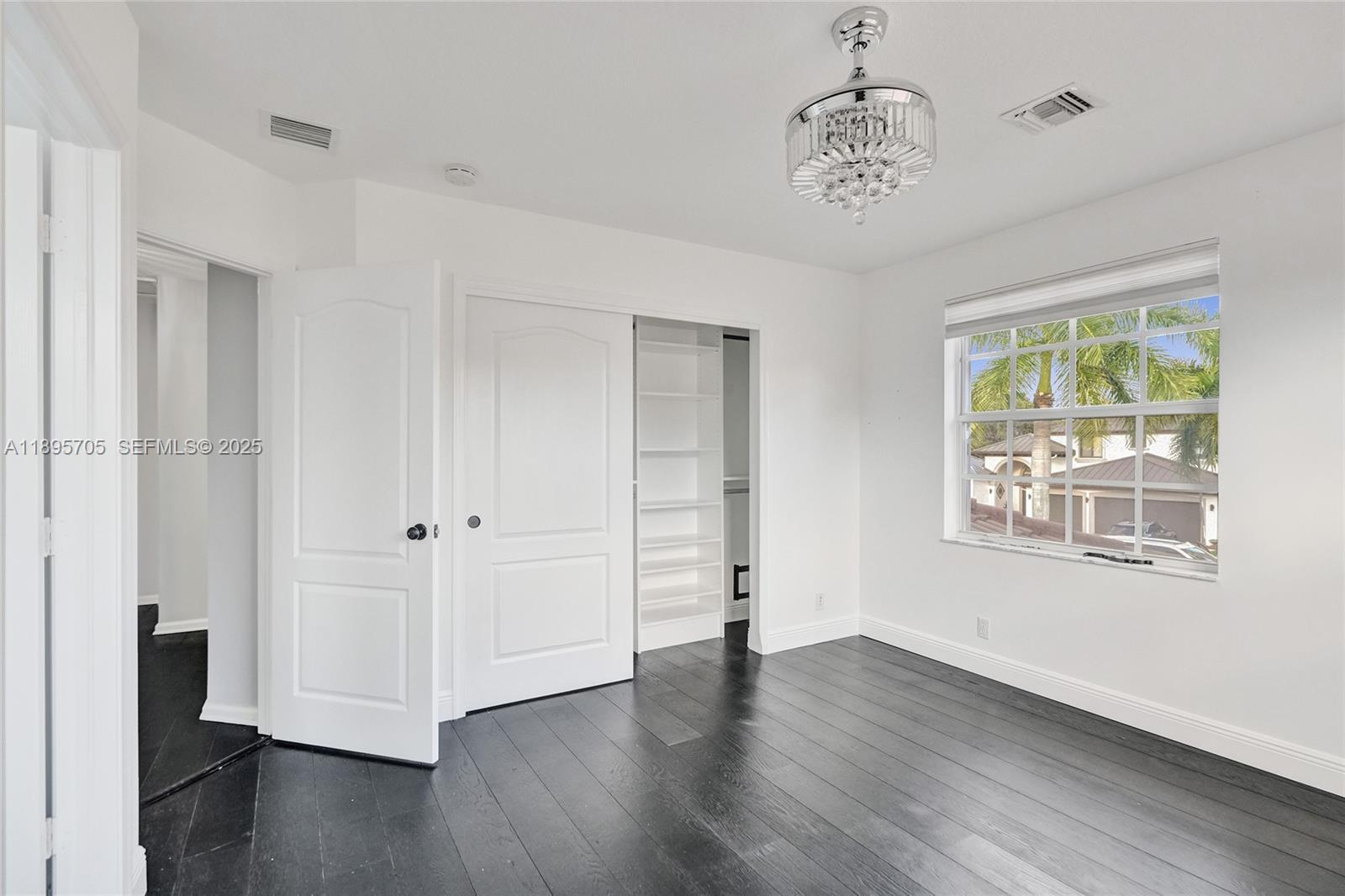 4248 Southwest 185th Avenue Miramar, FL 33029 - Photo 59 of 88 a view of an empty room with wooden floor and a window
