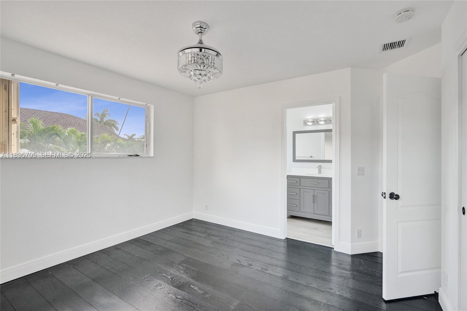 4248 Southwest 185th Avenue Miramar, FL 33029 - Photo 60 of 88 a view of an empty room with a window and wooden floor
