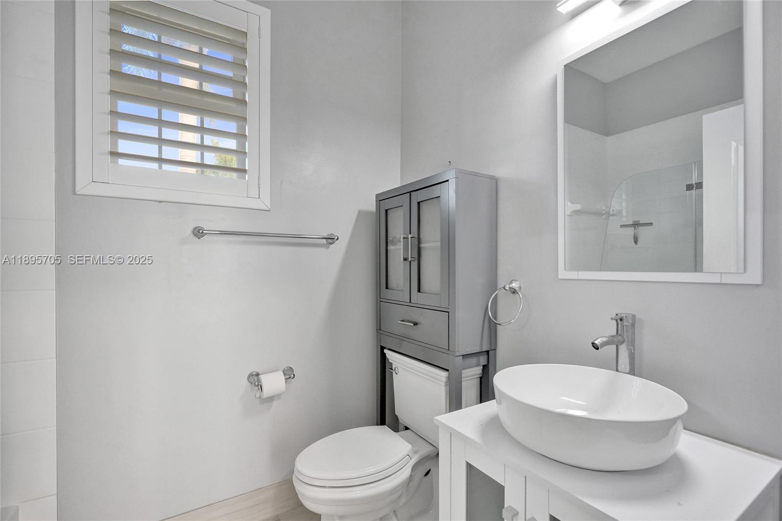 4248 Southwest 185th Avenue Miramar, FL 33029 - Photo 69 of 88 a bathroom with a toilet a sink a mirror and a window