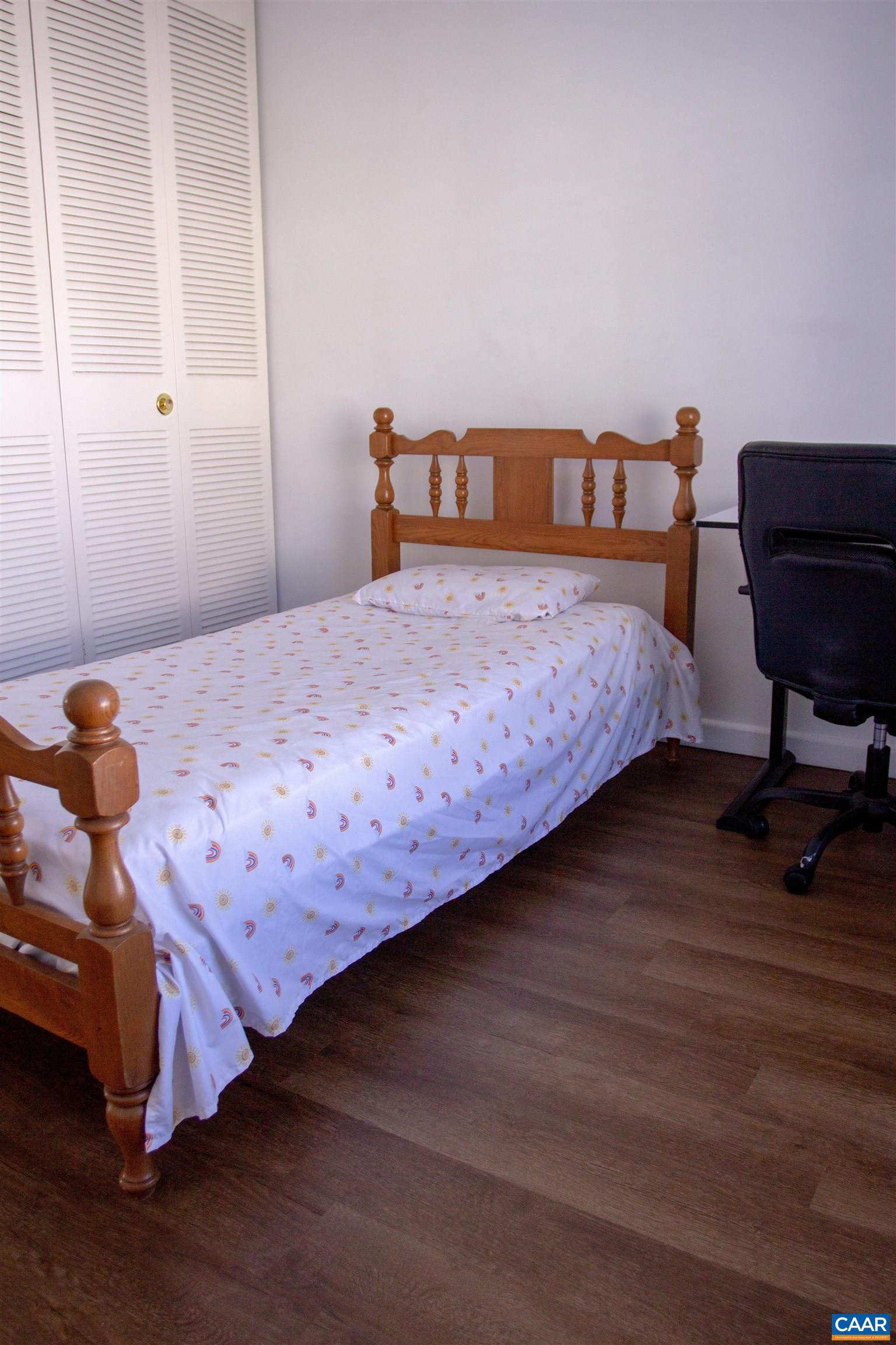 2527 Hydraulic Road, Unit 34 Charlottesville, VA 22901 - Photo 6 of 10 a bedroom with a bed and wooden floor