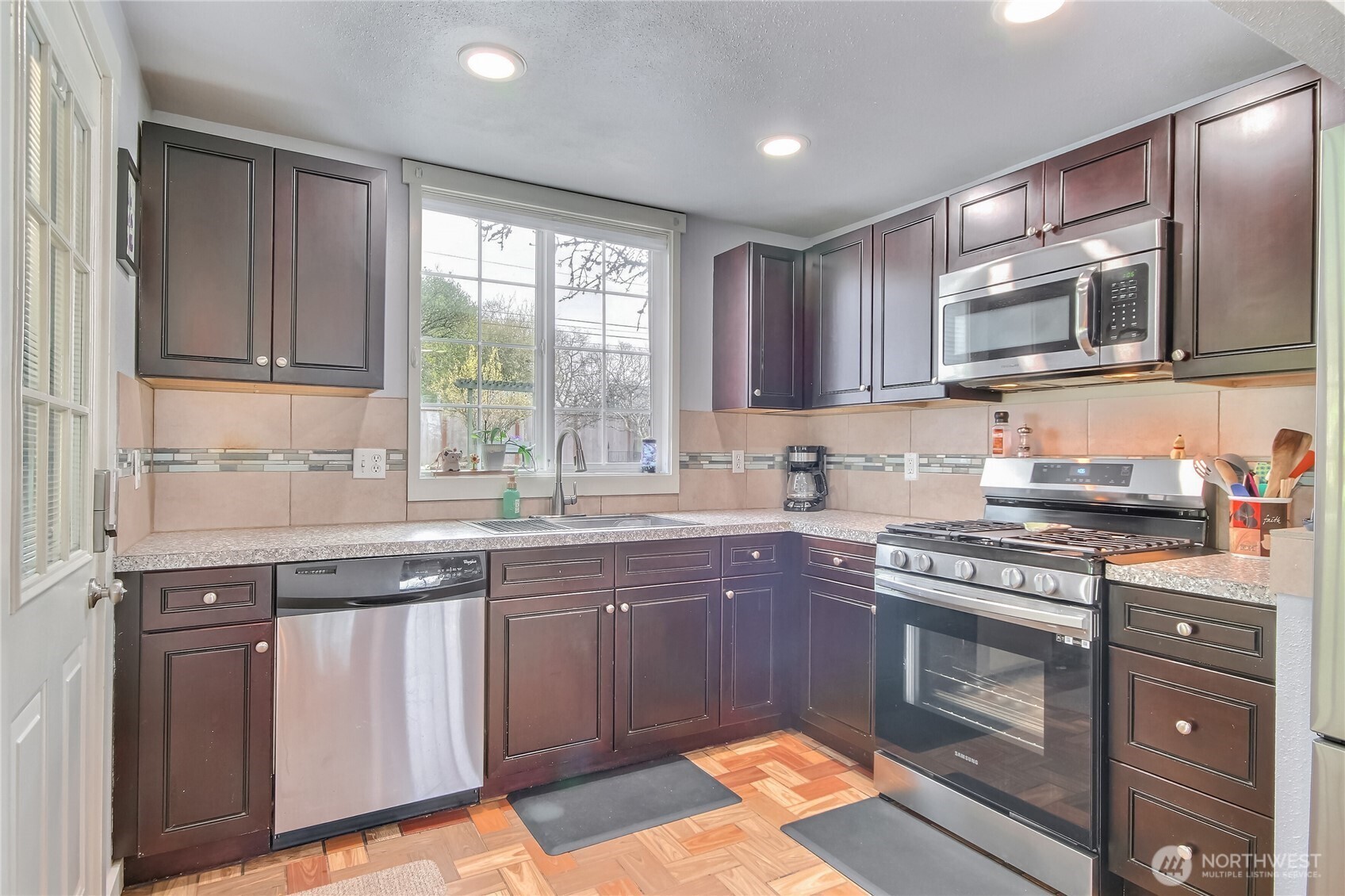 7417 South Prospect Street Tacoma, WA 98409 - Photo 12 of 35 a kitchen with stainless steel appliances granite countertop a stove sink and cabinets