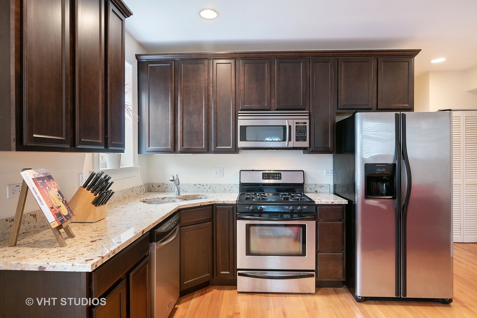 3339 West Byron Street, Unit 1 Chicago, IL 60618 - Photo 5 of 12 a kitchen with granite countertop stainless steel appliances a stove microwave and refrigerator