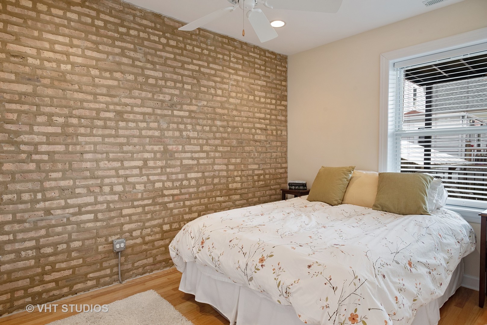 3339 West Byron Street, Unit 1 Chicago, IL 60618 - Photo 8 of 12 a bedroom with a bed and a brick wall