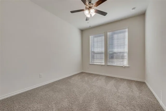 an empty room with a ceiling fan and a window