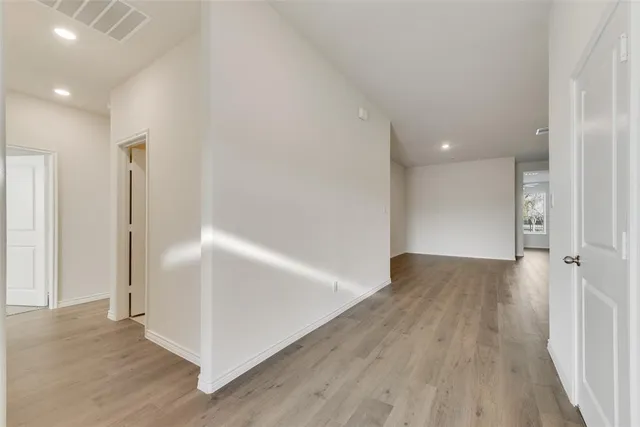an empty room with wooden floor and entrance