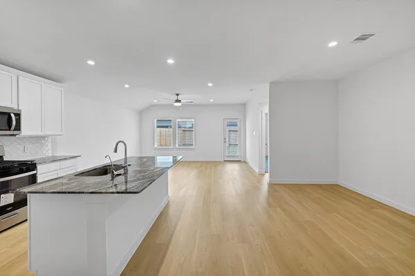 a kitchen with kitchen island stainless steel appliances a sink stove and refrigerator