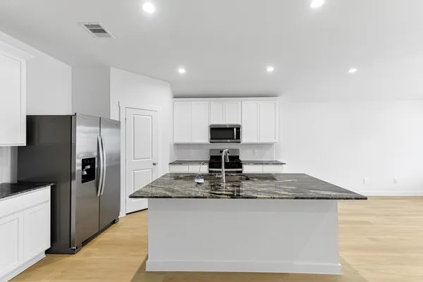 a kitchen with stainless steel appliances granite countertop a sink stove and refrigerator