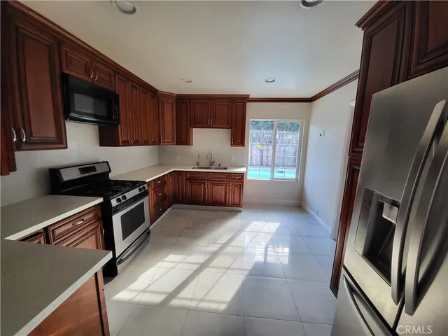 a kitchen with stainless steel appliances granite countertop a refrigerator and a stove top oven