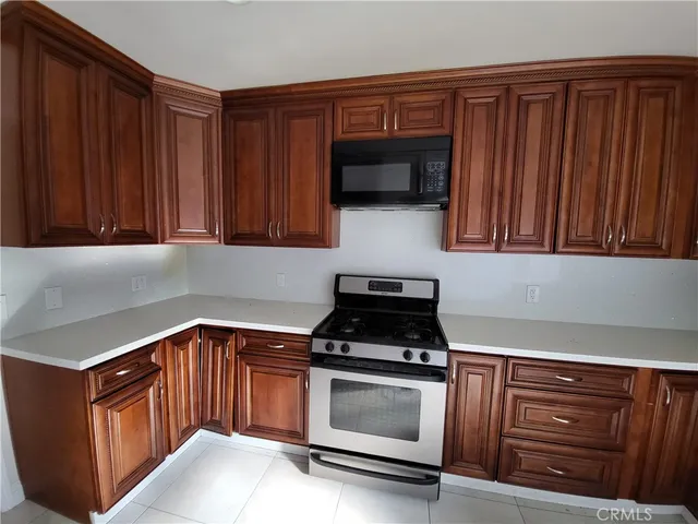 a kitchen with stainless steel appliances wooden cabinets and a stove top oven