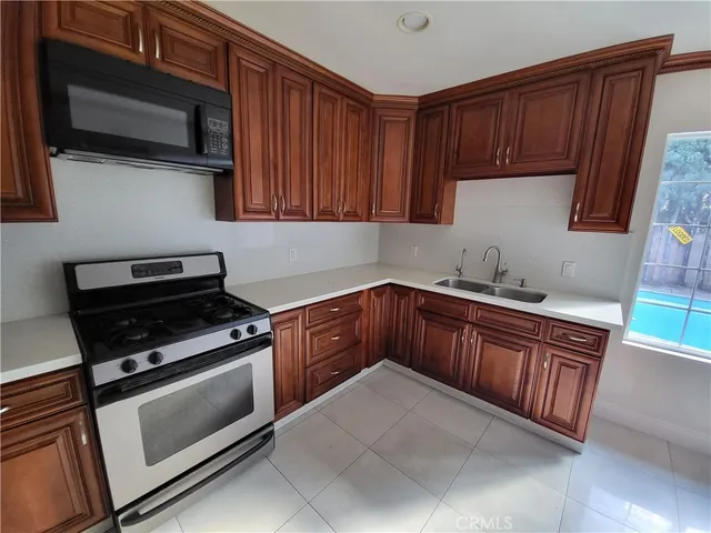 a kitchen with granite countertop wooden cabinets and stainless steel appliances