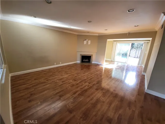 an empty room with wooden floor and fireplace