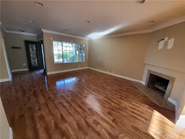 a view of empty room with wooden floor and fireplace