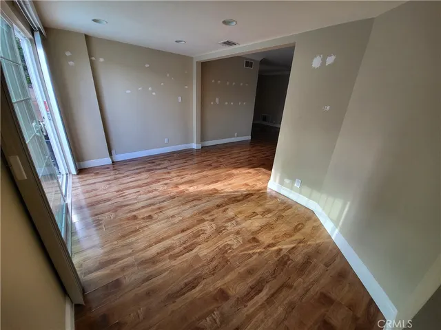 a view of a big room with wooden floor and staircase