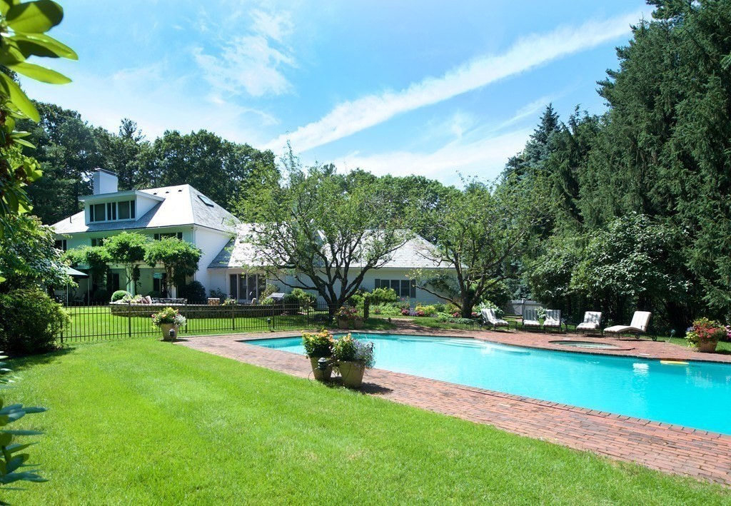 61 Possum Road Weston, MA 02493 - Photo 3 of 42 a view of swimming pool with lawn chairs under an umbrella