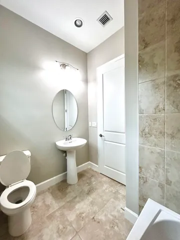 a bathroom with a sink toilet and a mirror