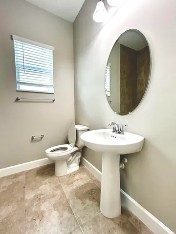 a bathroom with a sink a toilet and mirror