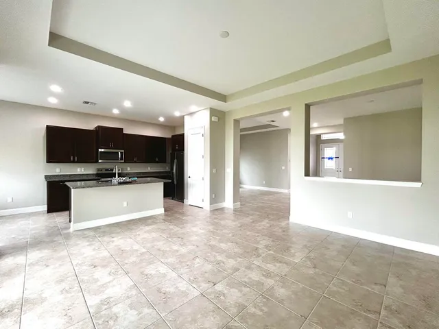 a view of kitchen with refrigerator sink and white cabinets