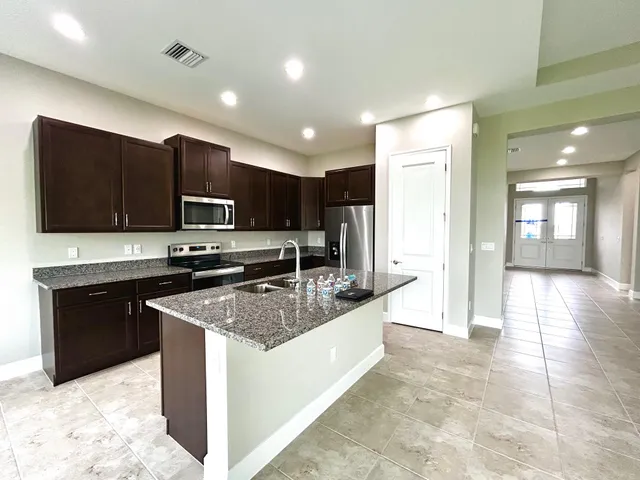 a kitchen with stainless steel appliances granite countertop a sink stove and refrigerator