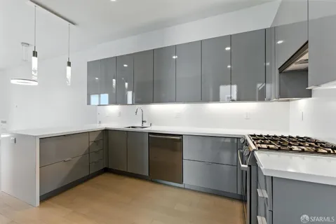 a metallic refrigerator freezer and a stove sitting inside of a kitchen