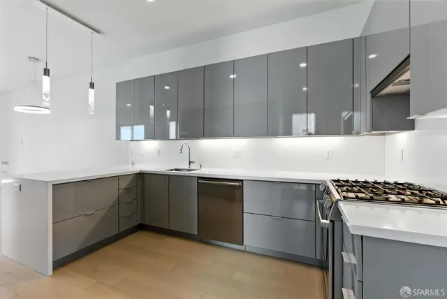 a metallic refrigerator freezer and a stove sitting inside of a kitchen