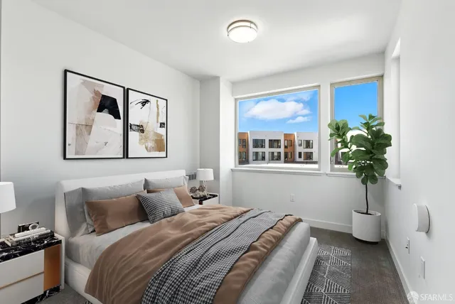 a roof deck with couple of couches and potted plants with wooden floor