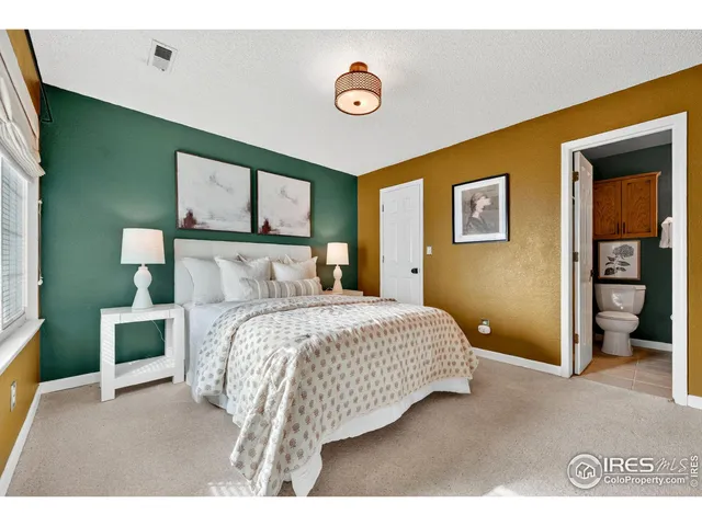 a bedroom with a bed and a painting on the wall