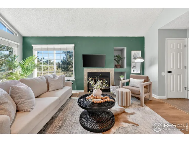 a living room with furniture a large window and a fireplace